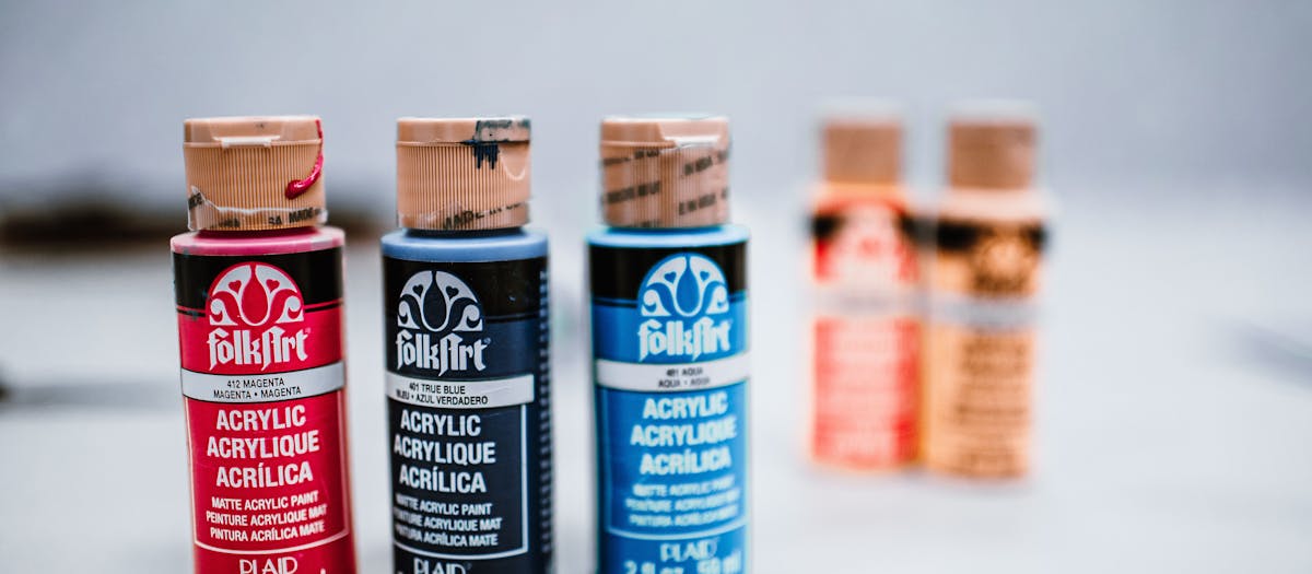 Colorful acrylic paint bottles displayed on a surface, perfect for creative art projects.